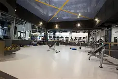 Sala de gimnasio en construcción, sin piso ni equipo instalado