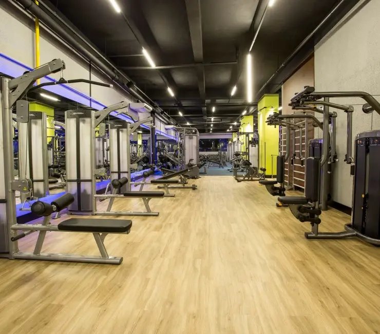 Zona de fuerza y cardio instalada, piso de madera, máquinas de poleas